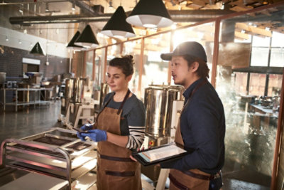 Abstract illustration of people interacting with colorful geometric block structures in a stylized environment.