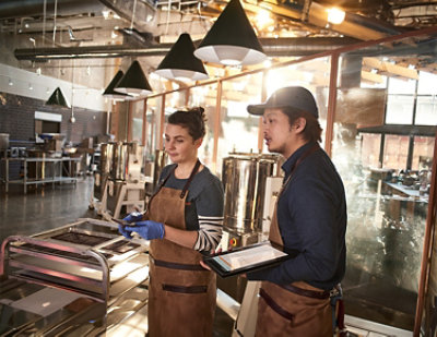Man and woman in aprons standing in a factory