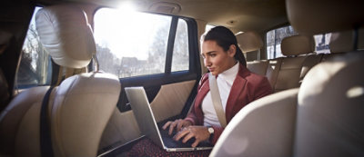 Woman in backseat of car, taking a business call