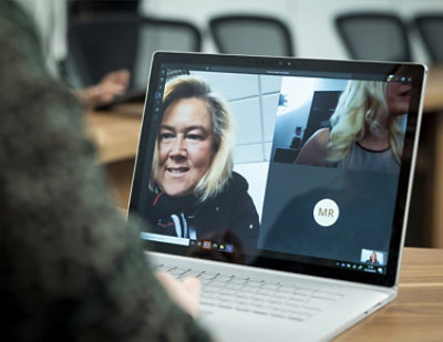 A woman with blonde hair using a laptop.