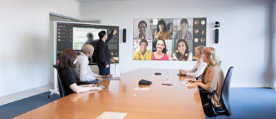 Un gruppo di persone che partecipano a una chiamata in videoconferenza in una sala riunioni moderna. 