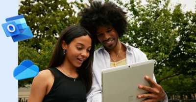 Two people standing outside looking at a tablet and having a conversation