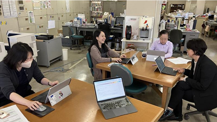 取手聖徳女子高等学校の教員が、職員室でICTを活用した探究学習とCopilotの実践について話し合っている様子