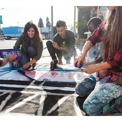 studenten schilderen aan de weg en een van hen laat een tabblad zien