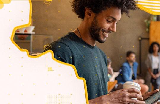 Pessoa com xícara de café usando tablet, fundo com mapa e padrões amarelos.