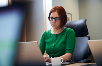 A person working on a laptop at their desk 