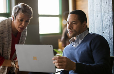 Two people having a conversation over a laptop 
