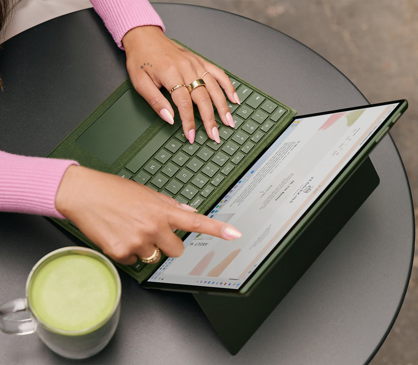 A person uses their finger to interact with the touchscreen of a Surface device.