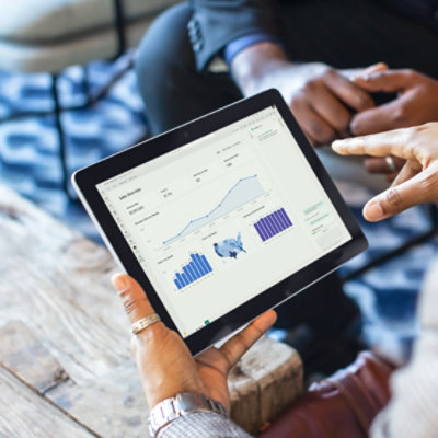 A person holding a tablet, working in a warehouse filled with boxes