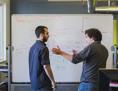 A man in a blue shirt stands in front of a whiteboard with text TEAM can Dapet== highit right w/ 51.