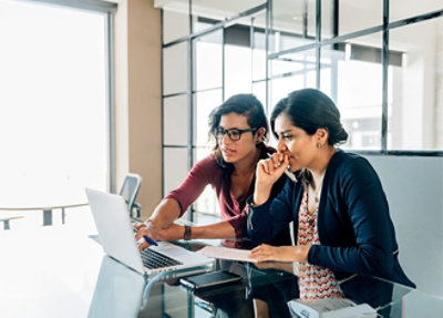 Two women looking at a laptop.