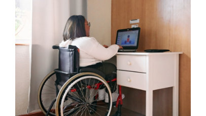 Young woman with a disability watching videos on her laptop.