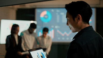 People collaborating in an office while reviewing business growth charts.