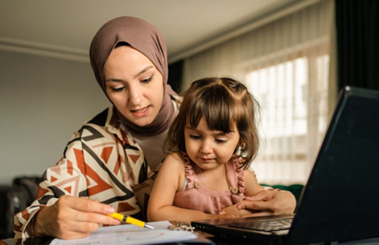 Mother and child working on a laptop.