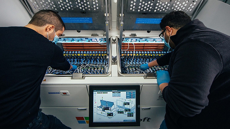 Dos empleados trabajando en un servidor del centro de datos.
