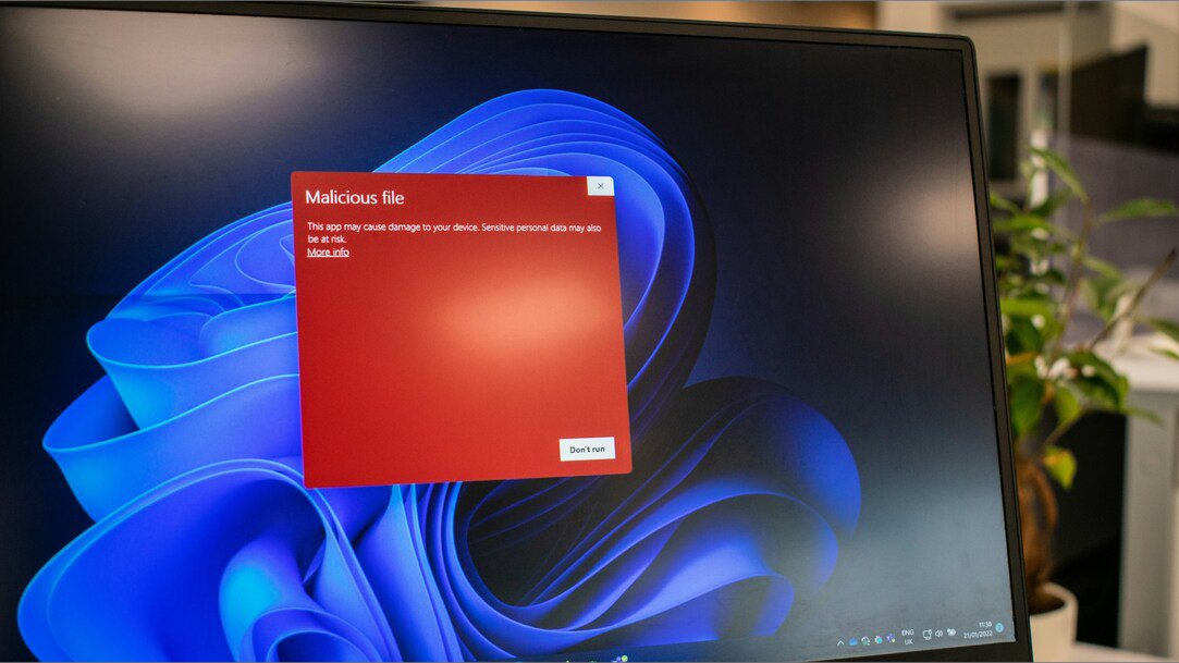 A Windows computer showing a red warning message about a malicious file