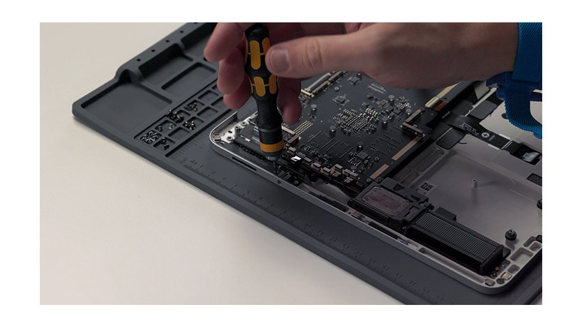 A close up image of someone repairing the inside of a Surface device