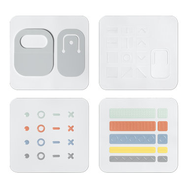 Abbildung von Teilen des Microsoft Adaptive Kits mit Kabelkennzeichnungen, Tastenkennzeichnungen und Öffnungshilfe.
