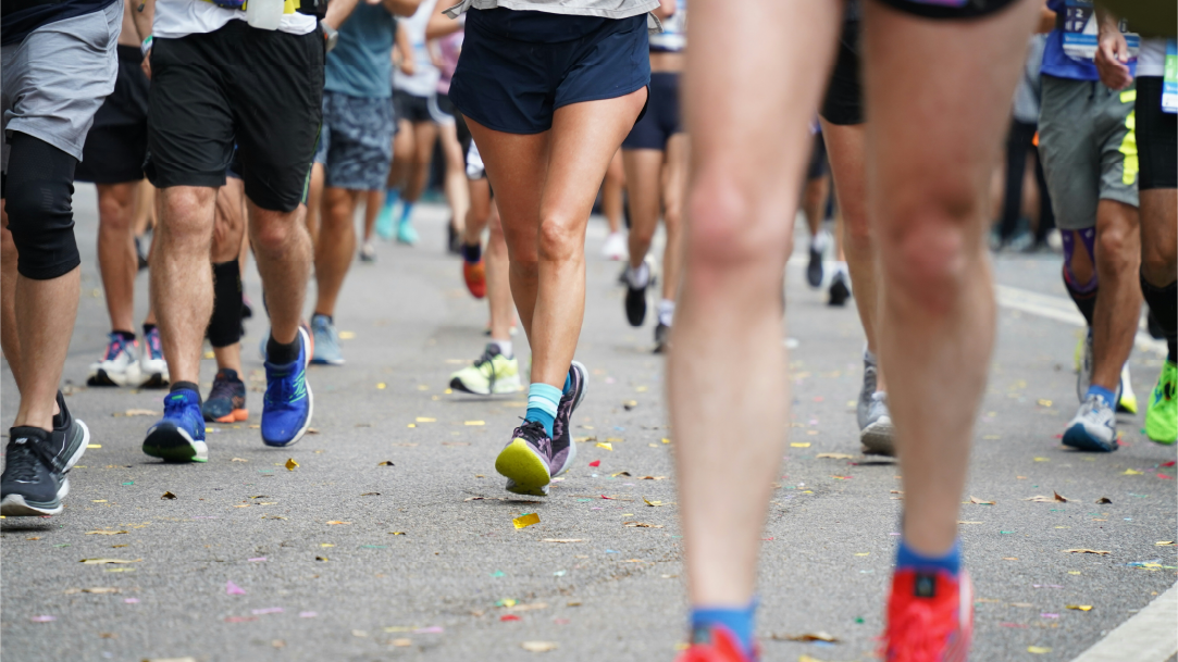 A close-up of people running on an asphalt road