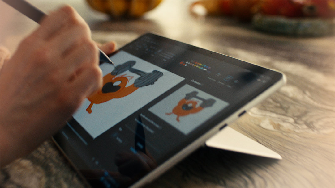 A closeup of a hand holding a Surface Slim Pen and drawing on the touchscreen of a Surface Pro