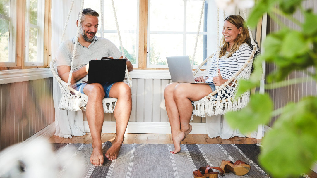A couple on their porch using their Windows 11 PC and a Copilot+ PC