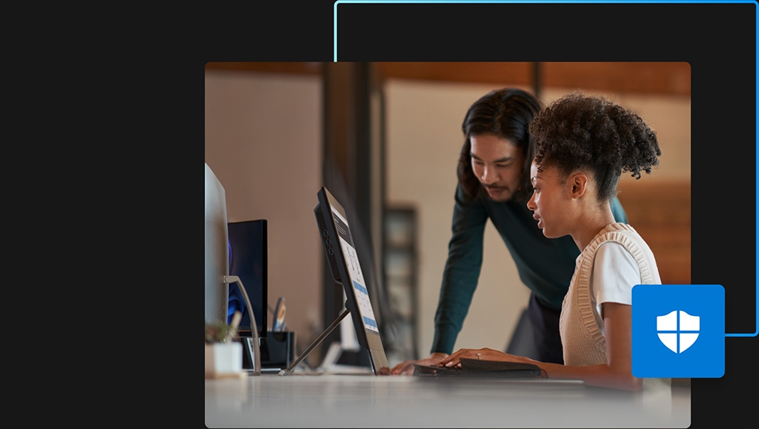 ovem sentada na mesa trabalhando na área de trabalho e um jovem inclinado a olhar