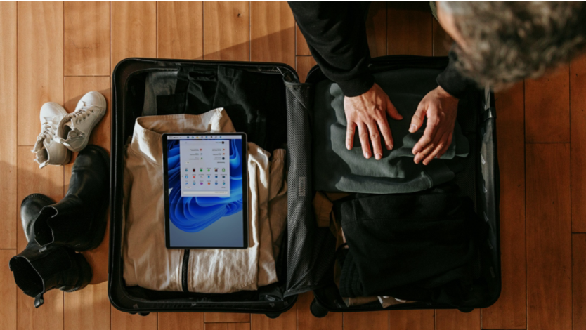 A digital nomad packs his Surface device in his suitcase