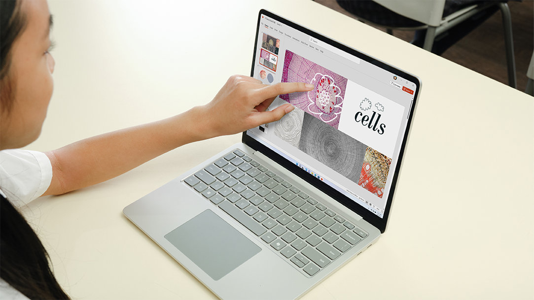 A female student using a Surface Laptop 13" Platinum touchscreen device
