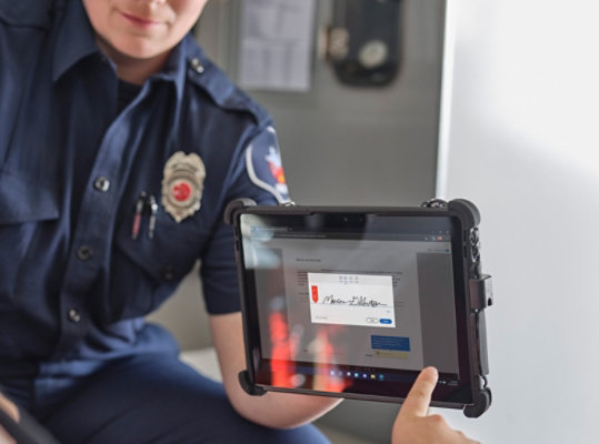 Członek służb ratowniczych udzielający pierwszej pomocy podaje pacjentowi urządzenie Surface do podpisu