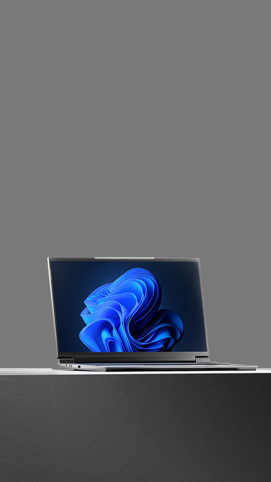 A laptop displaying the Windows 11 bloom desktop background screen