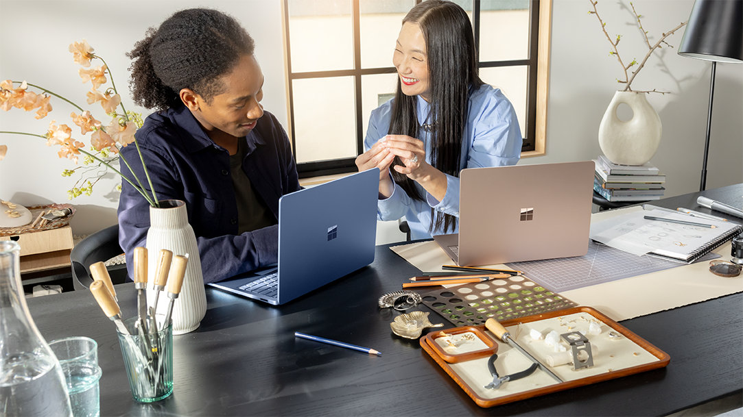 A man and woman standing with a laptop on a desk and collaborating on design ideas