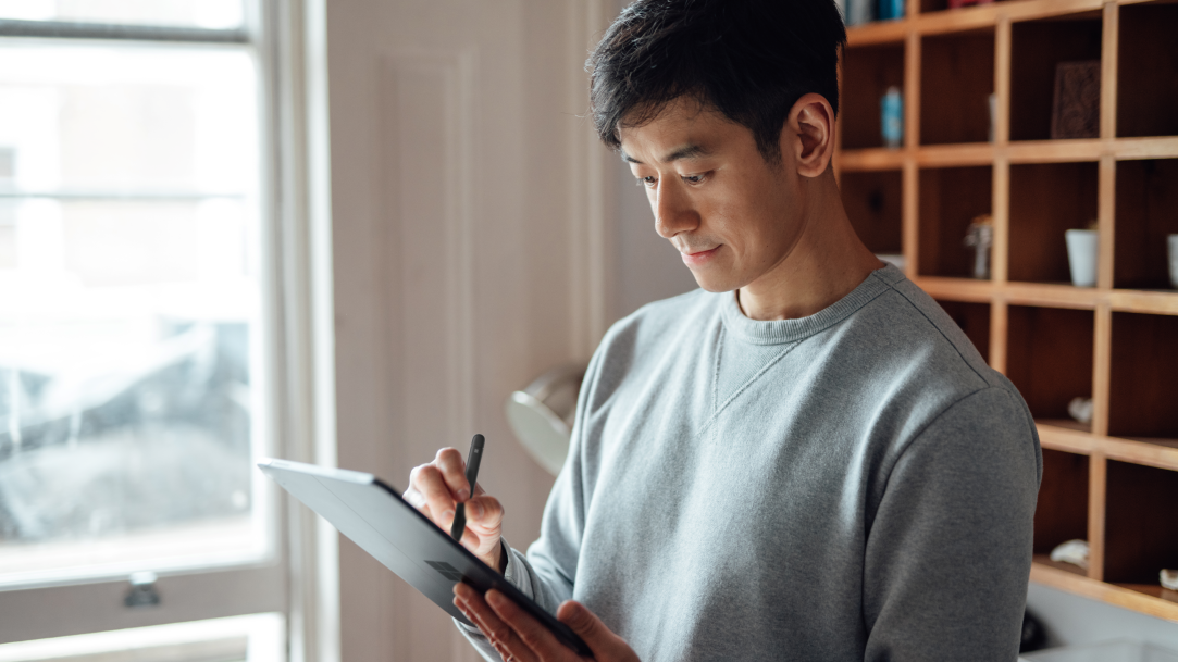 A man drawing on a tablet with a stylus