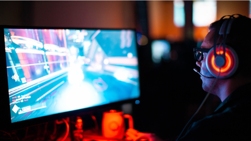 A man playing a video game on his desktop computer