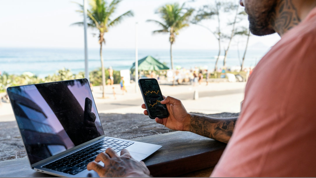 A man sitting outside at a resort holding his smartphone