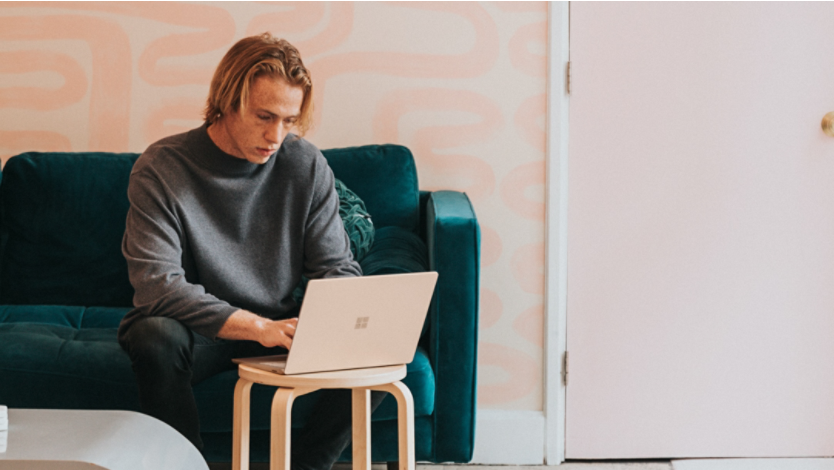 A person using Surface laptop on couch