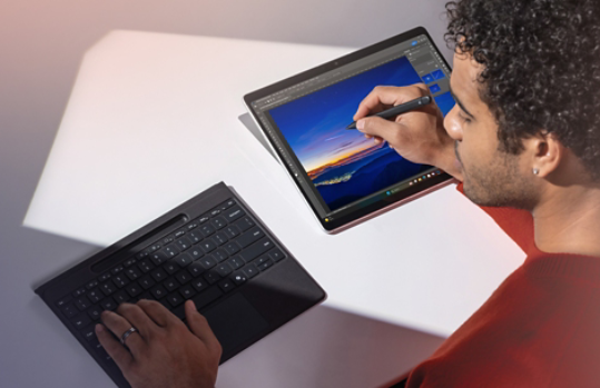 A man using a Surface Pro 11th Edition with a detachable Surface Pro Flex Keyboard and Surface Slim Pen