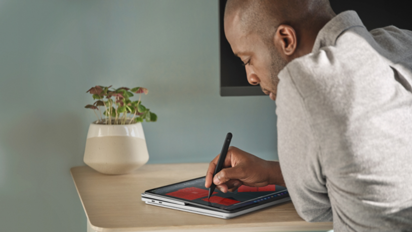 A man using a Surface device with a pen