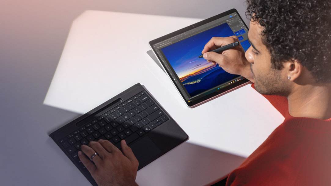 A man using a detached Surface Pro Flex Keyboard while writing on a Surface Pro 11ᵗʰ Edition with a Surface Slim Pen