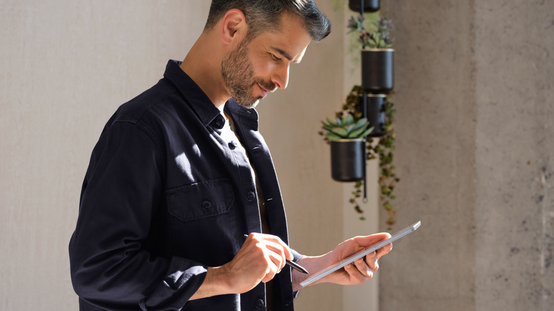 A man using a digital pen on a Surface laptop