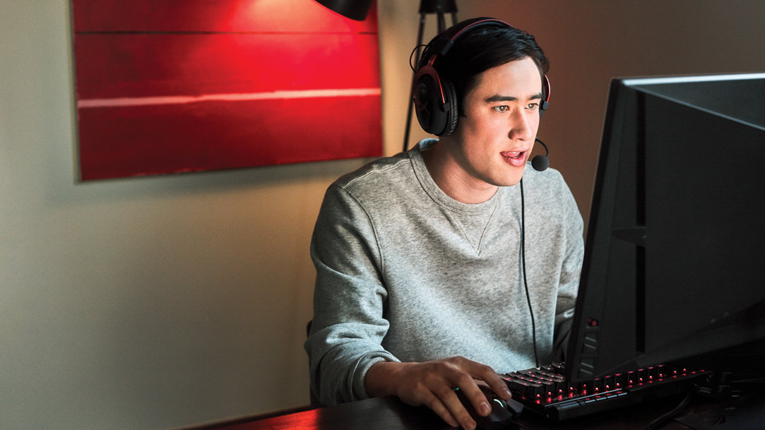 A man wearing a headset and mic while typing on a Windows PC