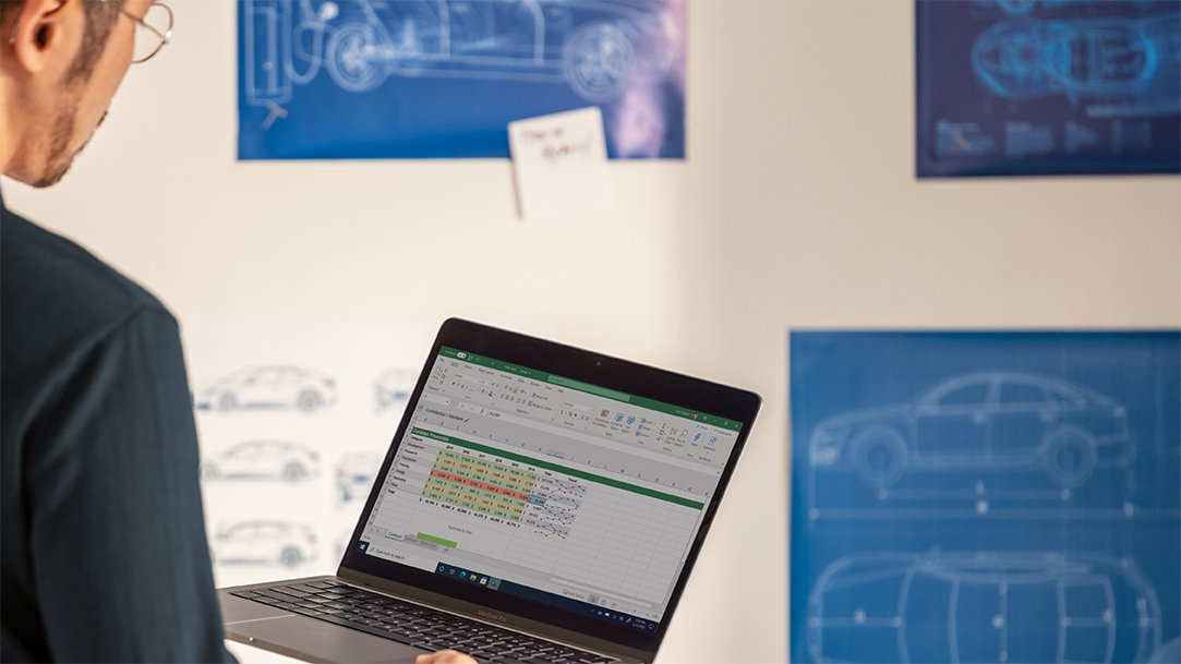 A man working on Excel on his Windows Surface laptop computer