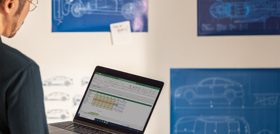 A man working on Excel on his Windows Surface laptop computer