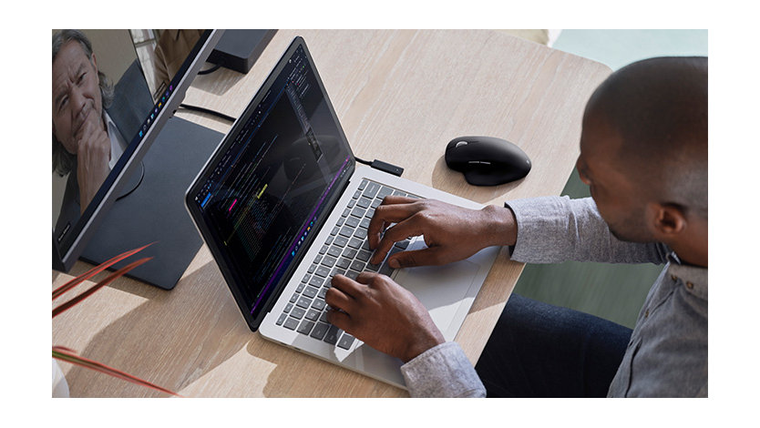 自分の机で Surface Studio で作業する男性