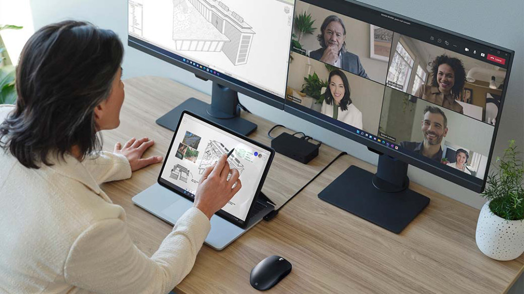Personne interagissant sur l’écran du Surface Laptop Studio connecté à des écrans externes
