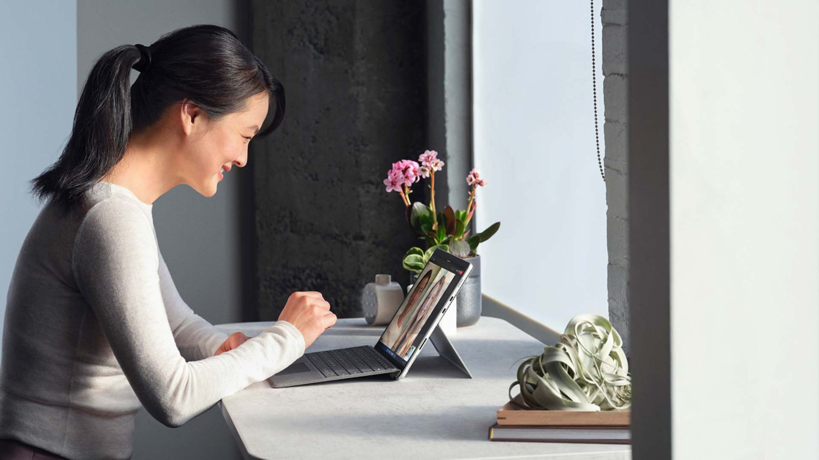 원격 작업 환경에서 Surface Pro 8 디바이스로 Microsoft Teams 통화를 진행 중인 사람