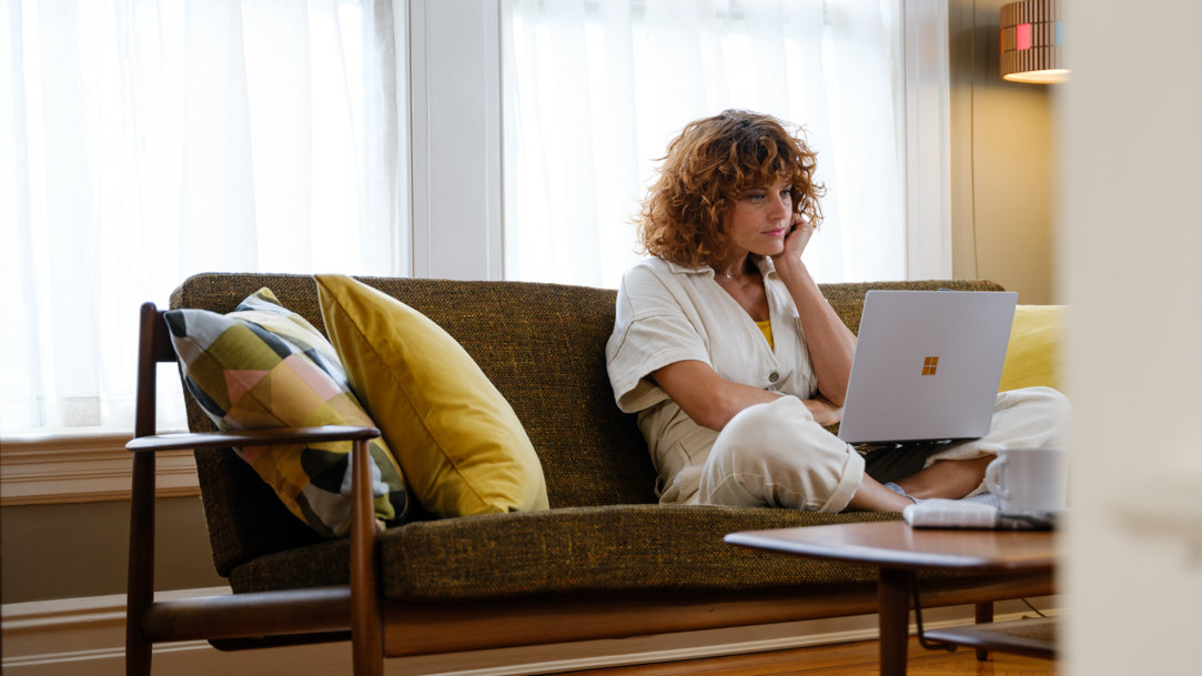 A person sitting on a chair using a laptop