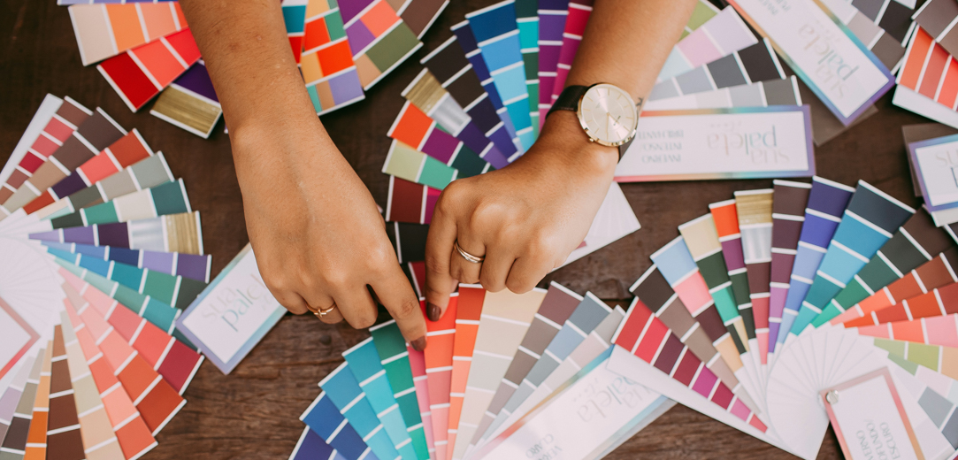 A person sorting through an assortment of color palettes