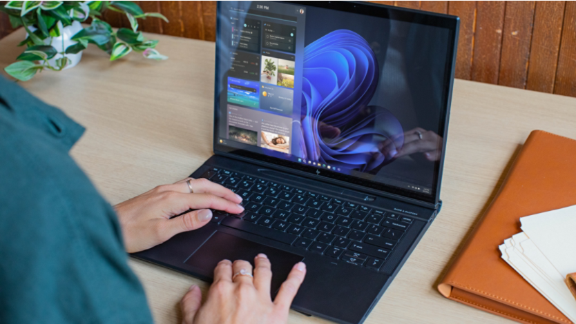 A person typing on a Windows laptop