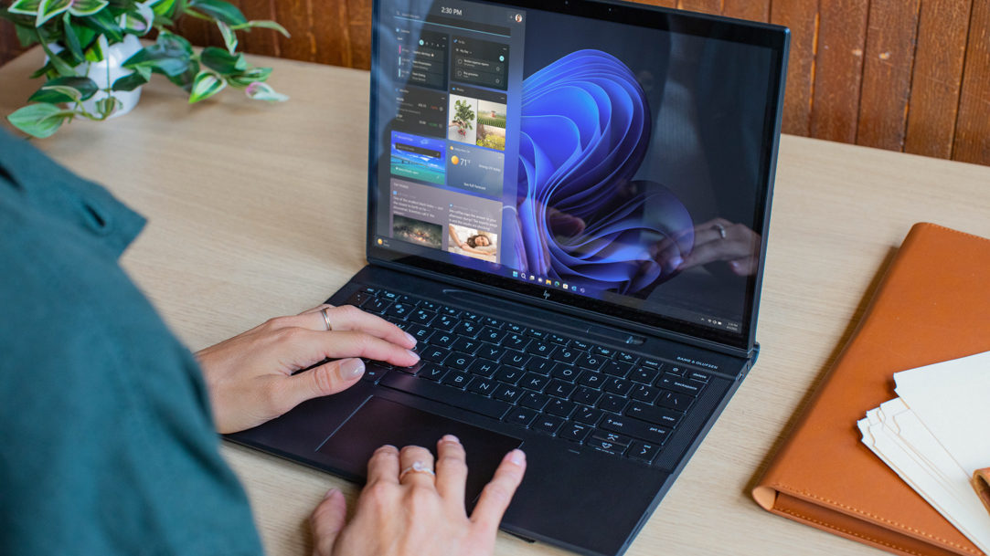 A person typing on a Windows laptop