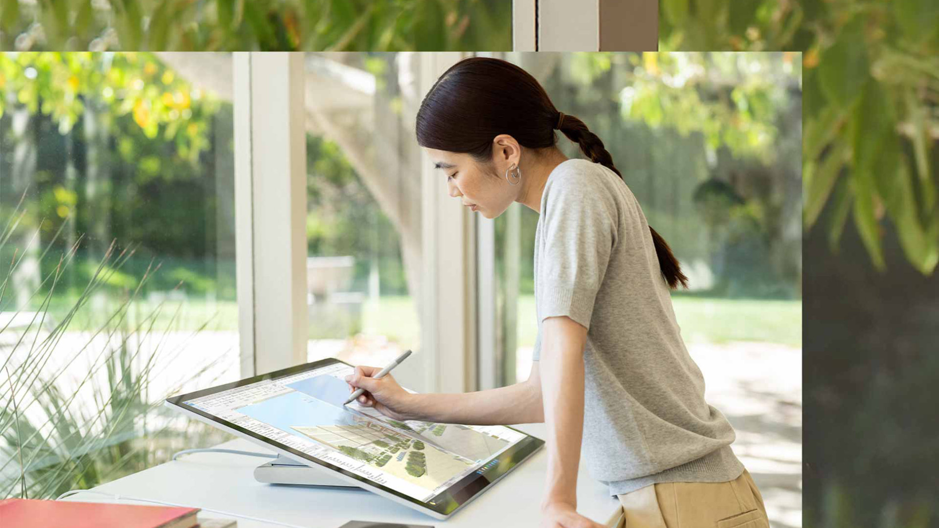 O persoană folosește creionul Surface pentru a scrie în cerneală pe ecranul unui dispozitiv Surface Studio 2+ în biroul de acasă